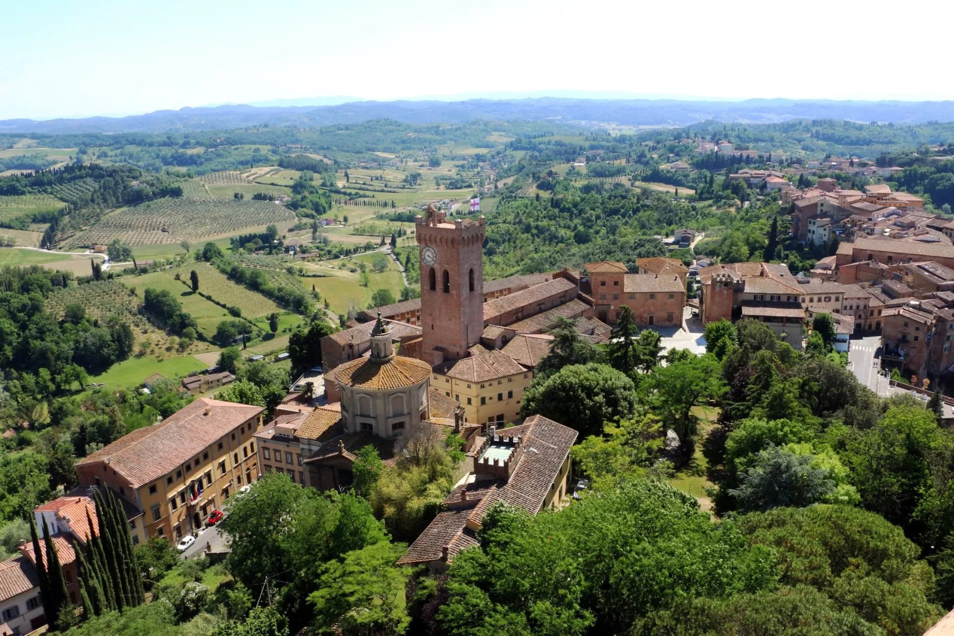View of San Miniato historic town with clock tower overlooking rolling Tuscan countryside.