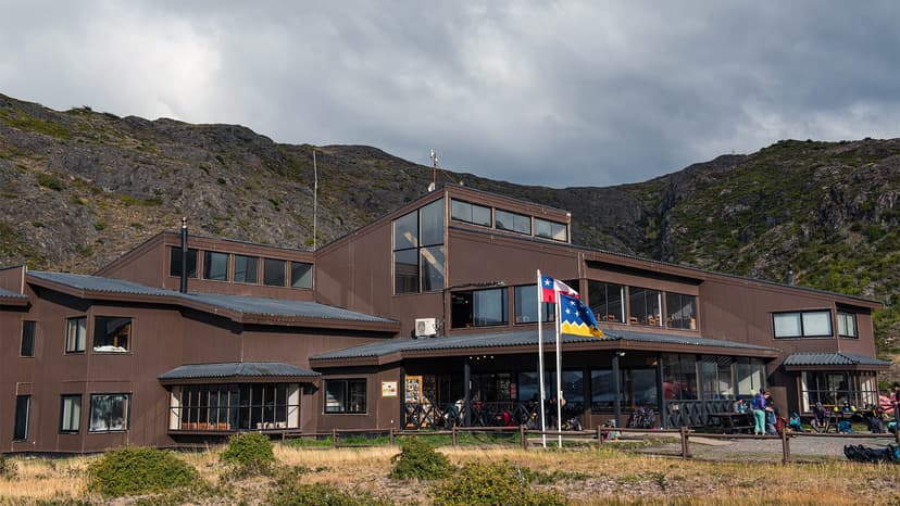 Lodge with brown siding and flags at Paine Grande near Pehoe Lake, Patagonia.