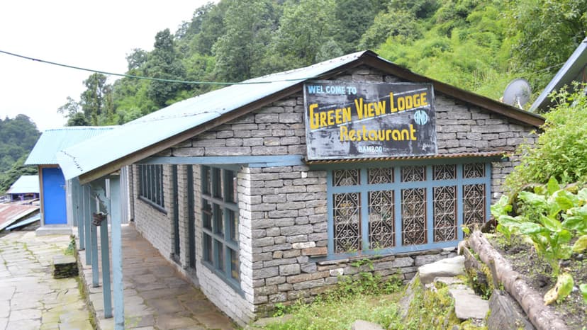 Green View Lodge Restaurant building with stone walls and blue trim in a lush, forested mountain setting.