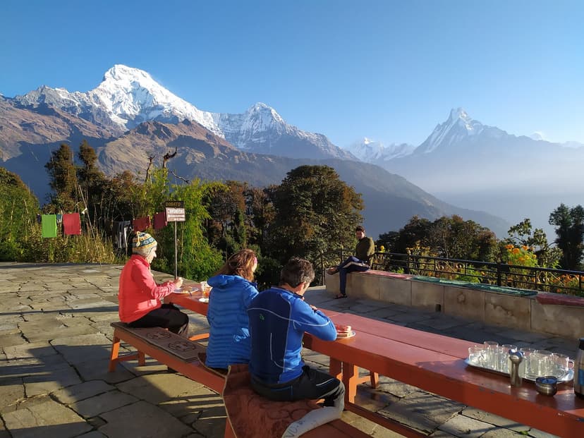 Hikers dining outdoors with Annapurna mountain range view at Hotel Grand View Tadapani.