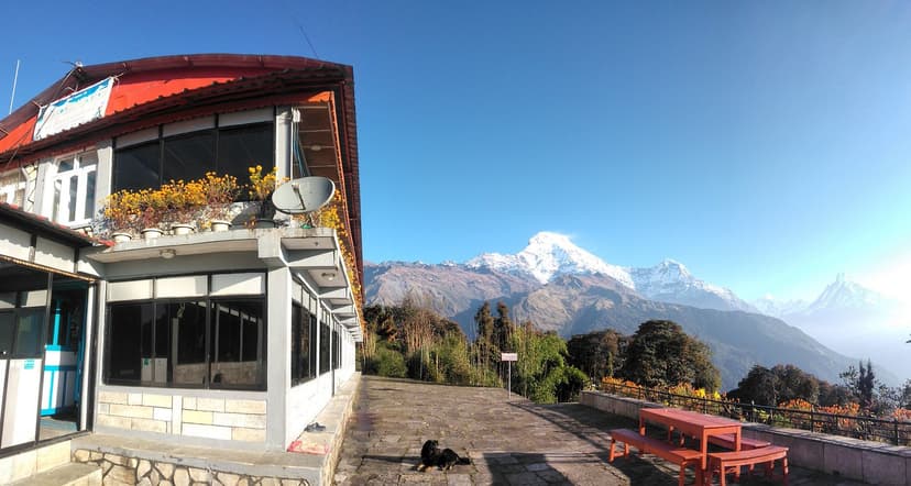 Hotel Grand View Tadapani with snow-capped Himalayan mountains under a clear blue sky.