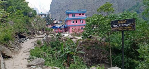 Himalayan Tourist Guest House in Jagat with sign pointing toward Larke Pass on stone path.