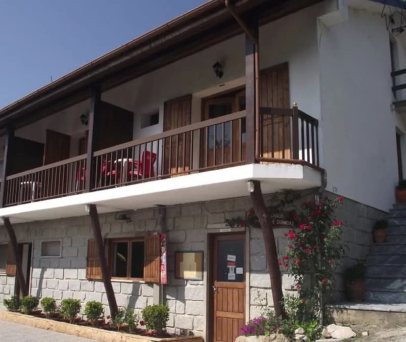 Stone and white building with wooden balconies, Casa do Criado in Geres outside.
