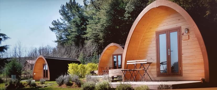 Wooden glamping pods with outdoor seating at Parque Biologico de Vinhais.