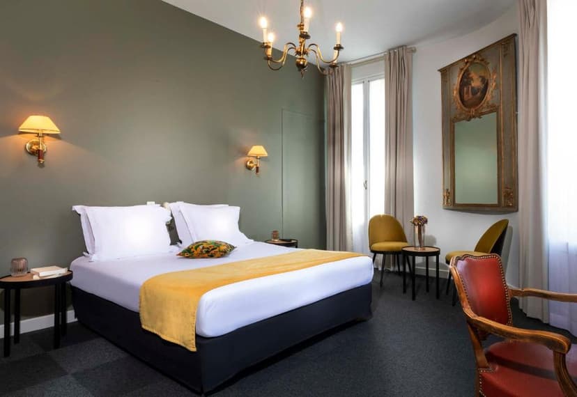 Bedroom in Hotel Saint Regis with double bed, brass chandelier, and antique mirror.