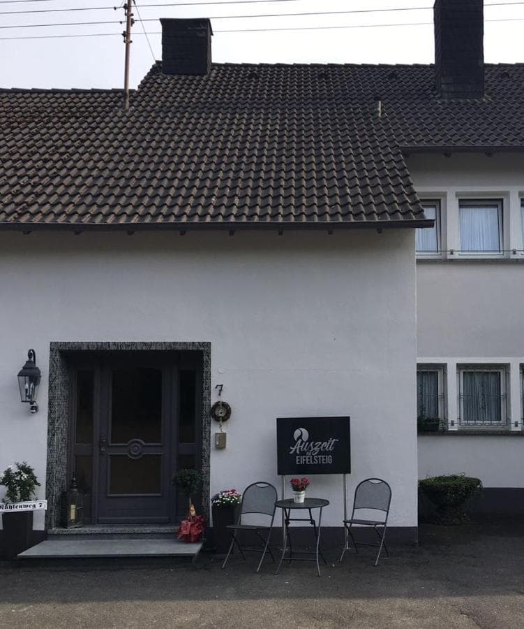 Entrance to Auszeit Eifelsteig accommodation with small outdoor seating area.