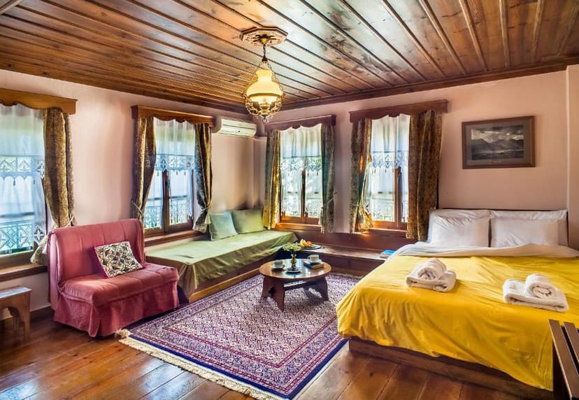 Cozy hotel room with wooden ceiling, yellow bed, and window seating area