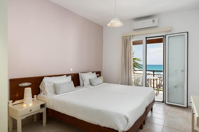 Hotel room with double bed, balcony access, and view of the blue sea