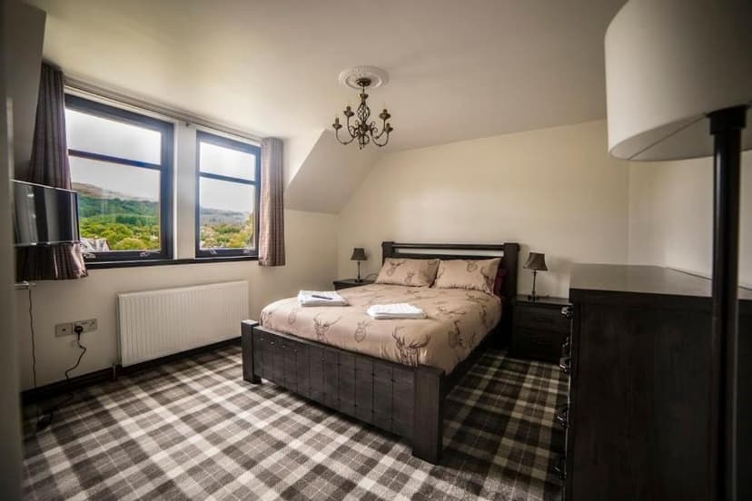 Bedroom in Whitehouse B&B with plaid carpet and view of green hills.