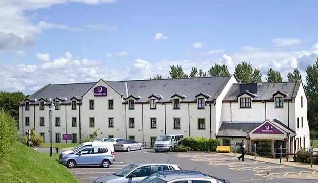 Premier Inn Glasgow (Milngavie) hotel exterior with parking lot and blue sky