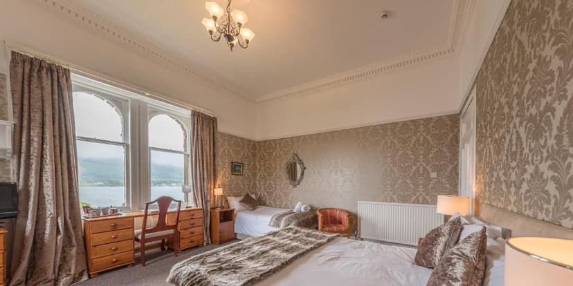 Hotel room with lake view, patterned wallpaper, and multiple beds at Craigard House Hotel.