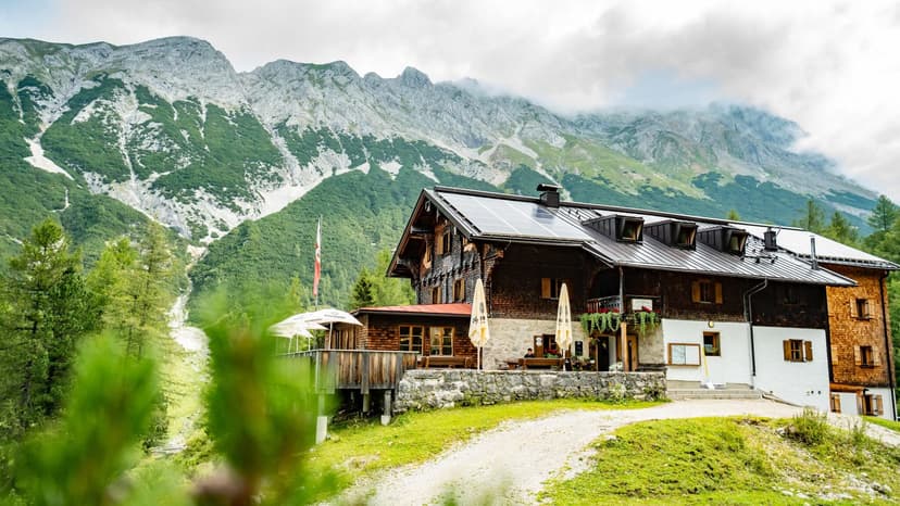 Hallerangerhaus mountain hut with solar panels set against steep, green and rocky alpine peaks.