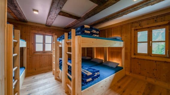 Bunk beds in a rustic wooden room with exposed beams, Hallerangerhaus.