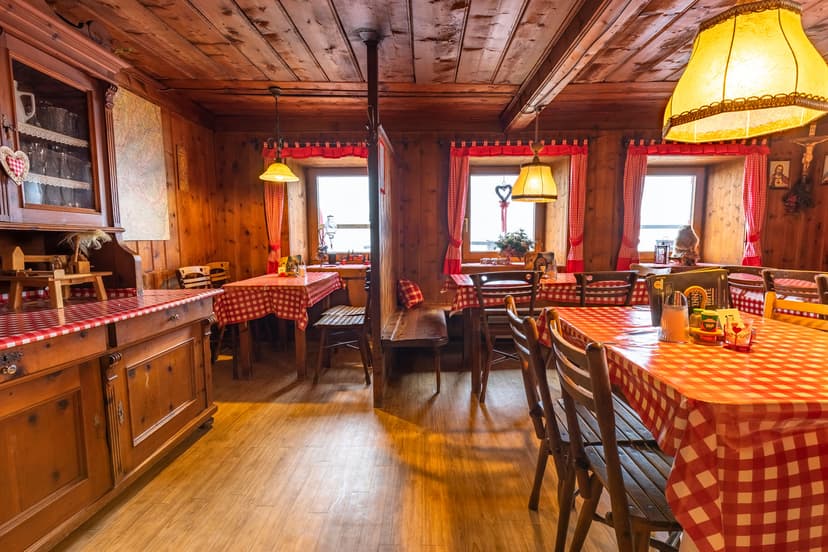 Rustic wooden interior of Innsbrucker Hütte restaurant with red checkered tablecloths.