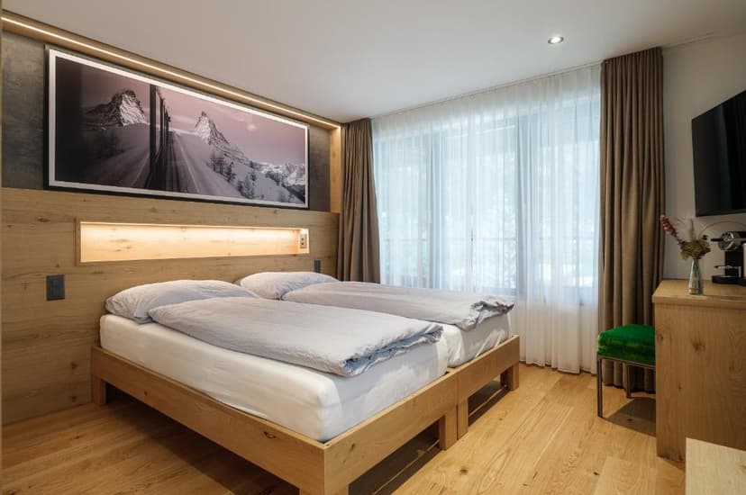 Twin beds in modern hotel room with wood paneling and mountain artwork