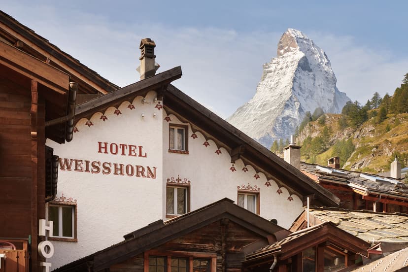 Hotel Weisshorn building with snowy mountain peaks in the background