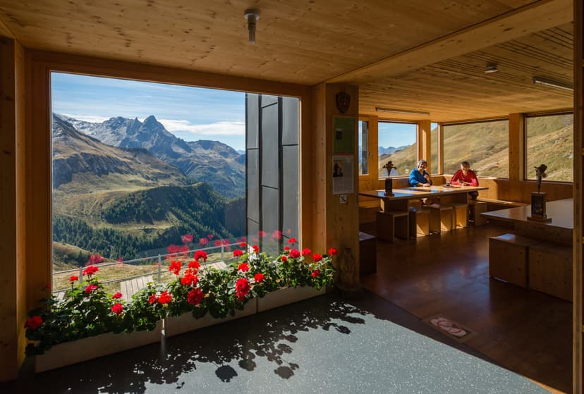 Interior of Capanna Michela Motterascio with alpine view and red flowers