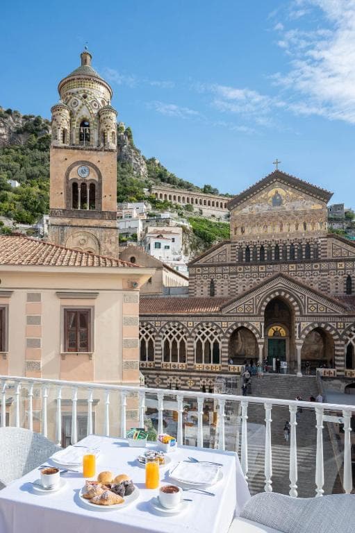 Breakfast on terrace overlooking Duomo di Sant'Andrea bell tower in Amalfi.