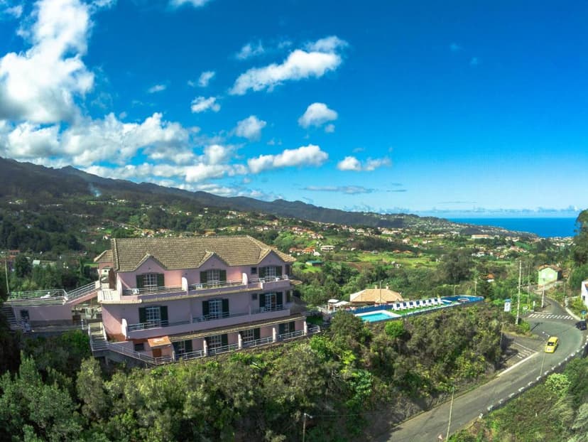 Pink Bed & Breakfast with pool on lush hillside overlooking coastal town and mountains