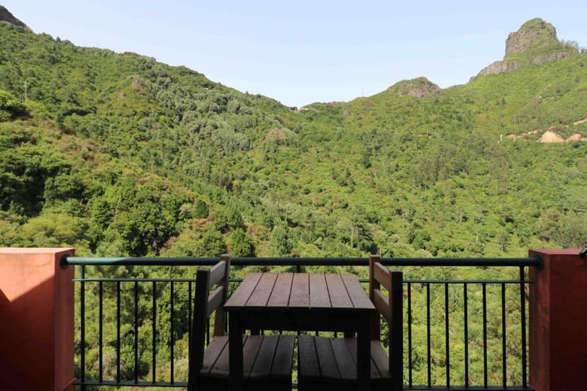 Balcony table with view of lush green mountains at Valley View Hotel Encumeada