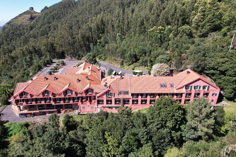 Hotel Encumeada with red tile roofs nestled in a dense, green mountain forest.