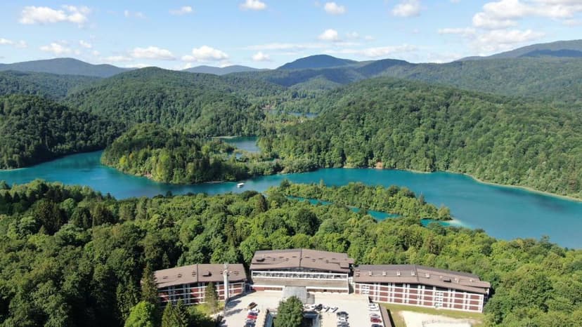 Hotel complex near turquoise lakes surrounded by dense green forest and mountains