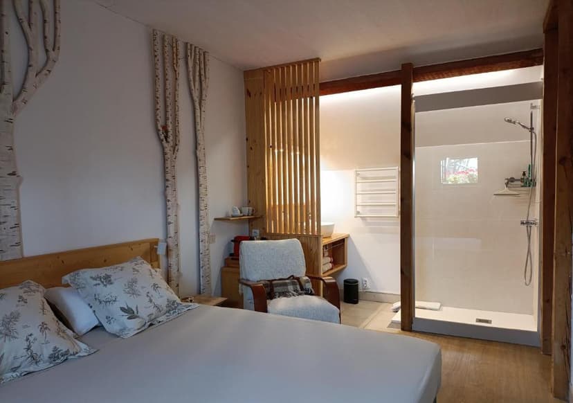 Bedroom with birch tree wall decor, wooden accents, and open shower area in Meyronne.