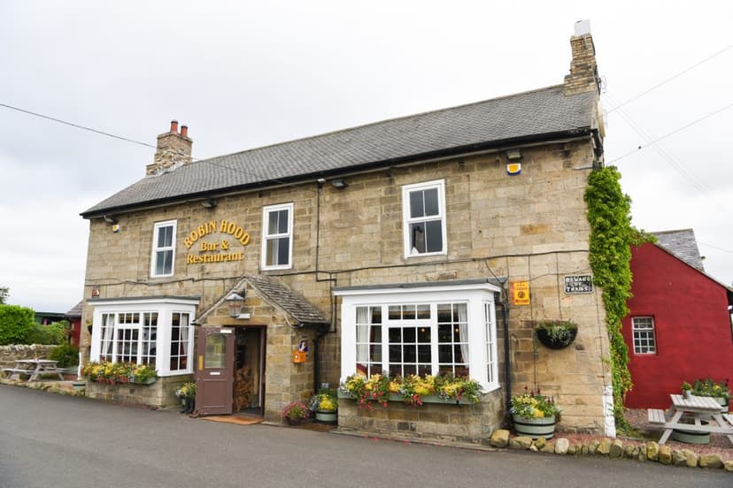 Robin Hood Bar & Restaurant in stone building with flower boxes and red annex.
