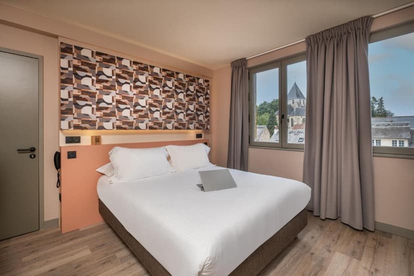 Hotel room with bed and view of historic church tower through window