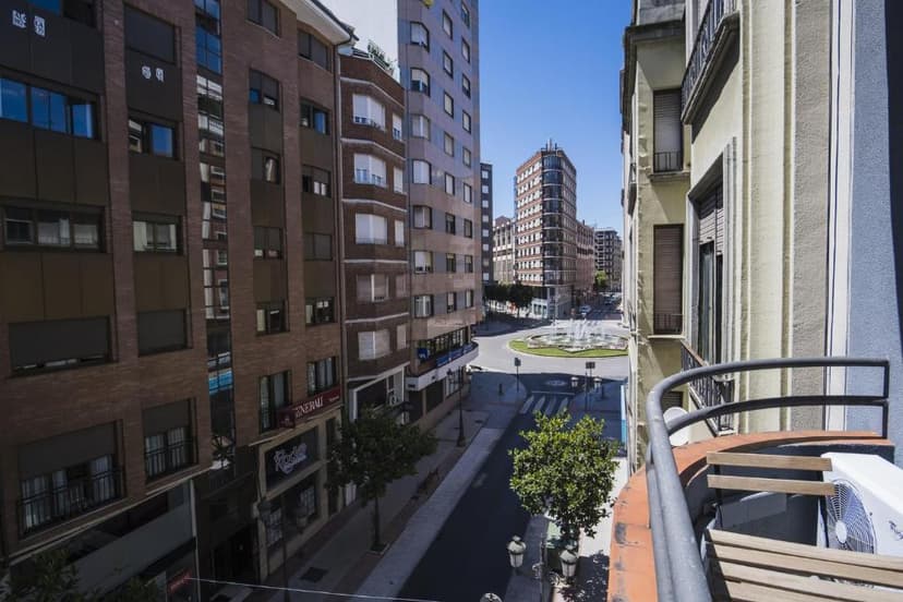 View from balcony over street to roundabout fountain in Ponferrada city center.