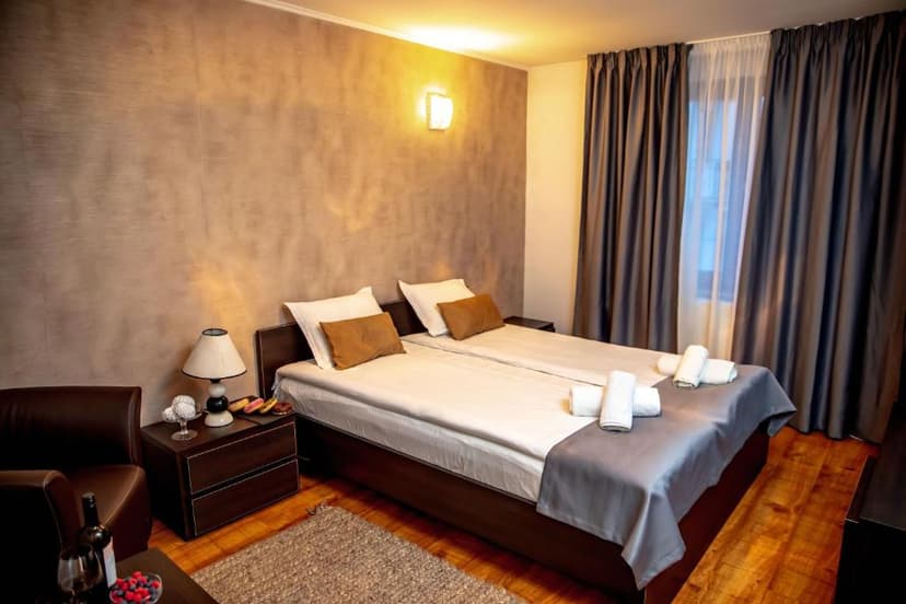 Twin beds in hotel room with dark wood furniture and textured brown accent wall