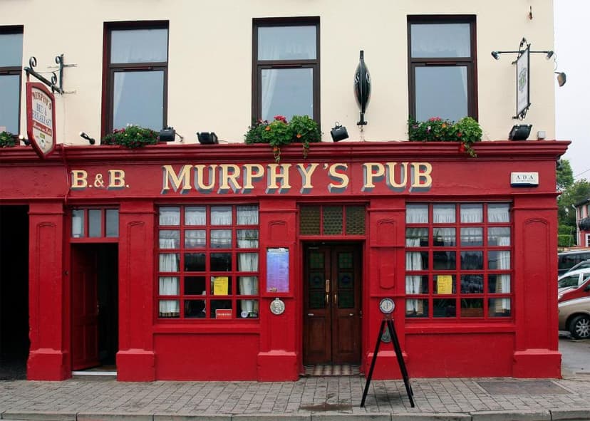 Murphy's Pub and B&B with a bright red facade and gold lettering on a paved street.