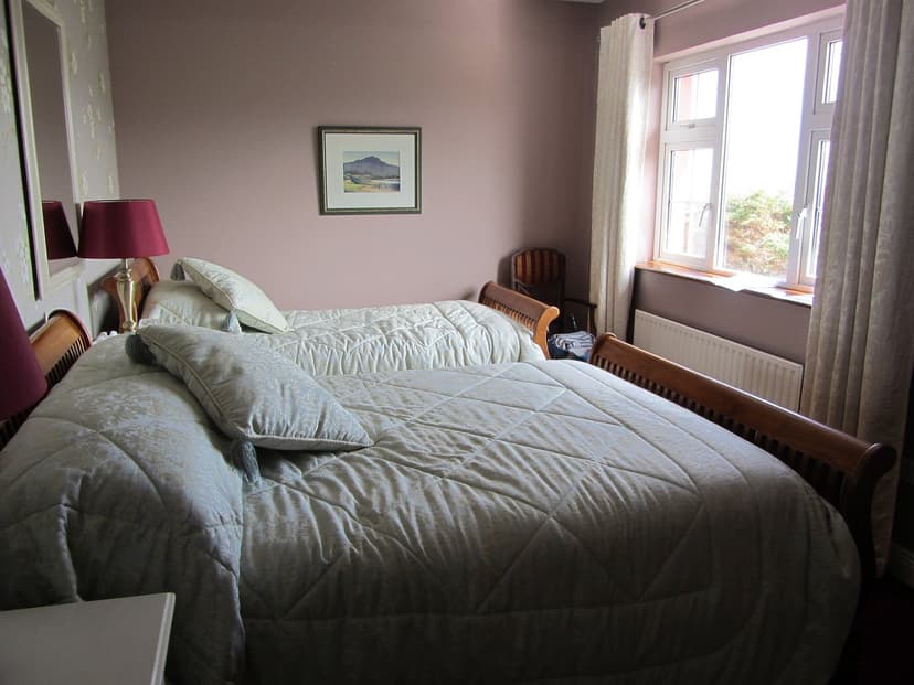 Twin beds with quilted light blue bedding in a Castle House Bed and Breakfast room.