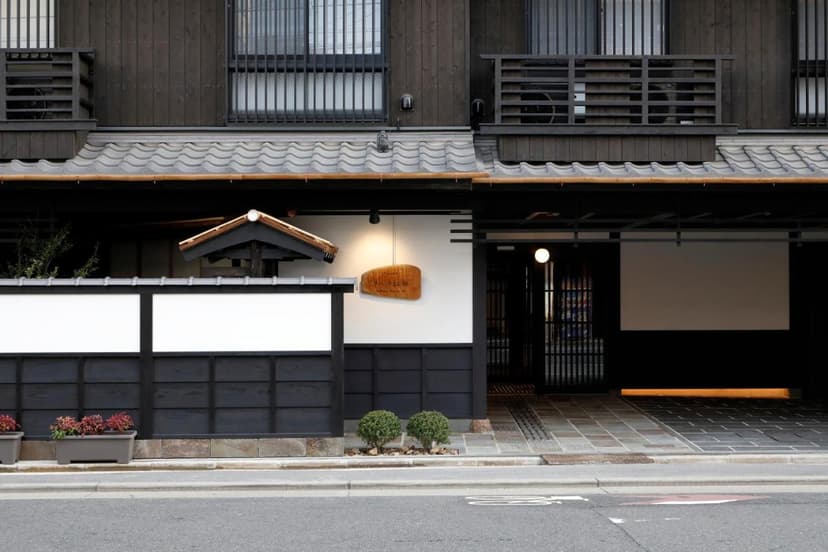 Kyomachiya Ryokan Sakura Urushitei entrance with dark wood, white walls, and tiled entryway.