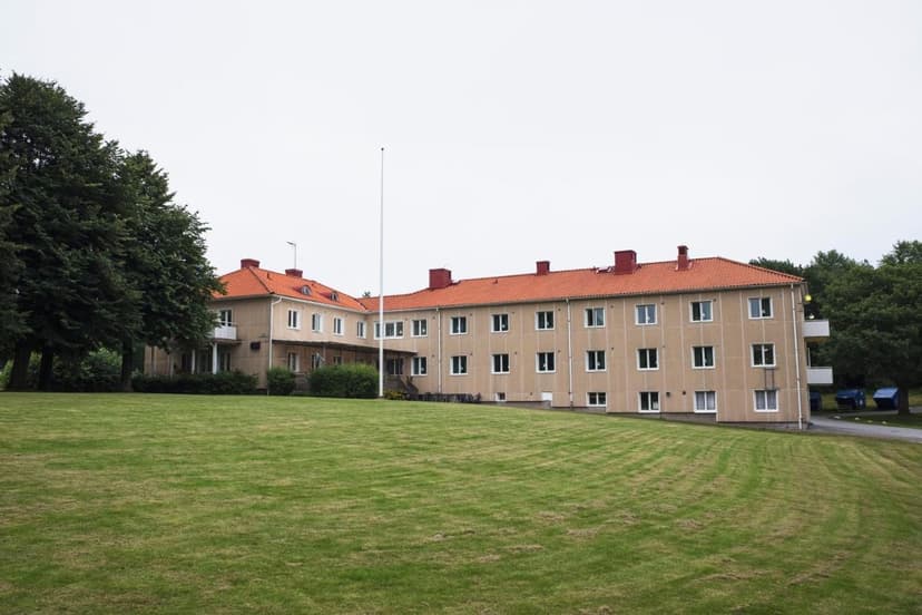 Partille Vandrarhem building with tan facade, red tile roof, and large green lawn.