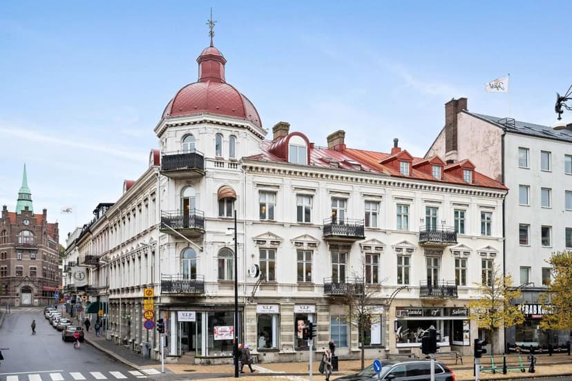 White historic building with red dome and balconies on a city street in Linnéa