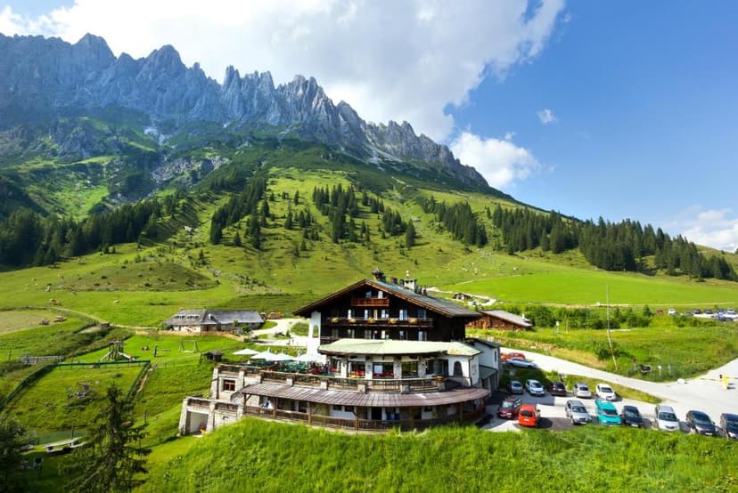 Berghotel Arthurhaus with parking nestled in green alpine meadows below rocky mountains