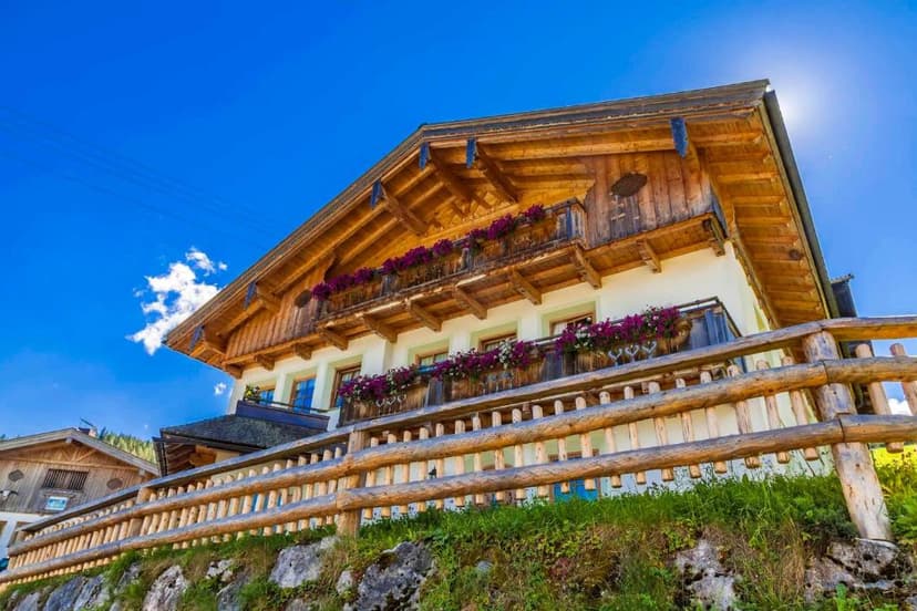 Alpine chalet with wooden balconies and flower boxes in Oberdachebenhof, Dienten.