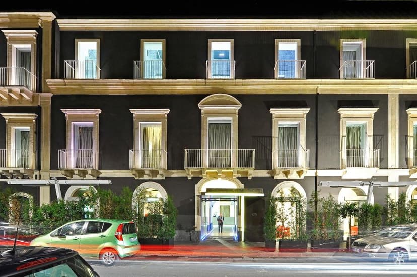 Hotel Romano House facade at night with cars passing by and illuminated entrance