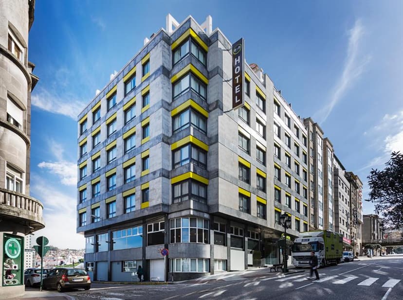 B&B Hotel Vigo exterior with gray and yellow accents on a sunny day in the city.