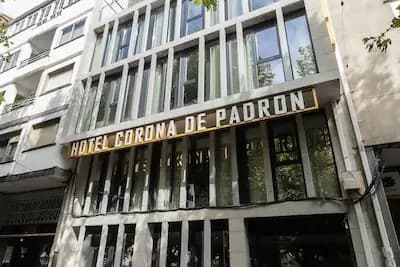 Hotel Corona de Padrón building facade with vertical concrete slats and large windows.