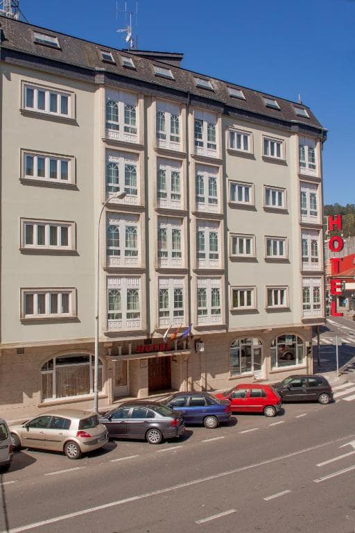 Hospedium Hotel La Marina building facade with parked cars on street, Costa da Morte