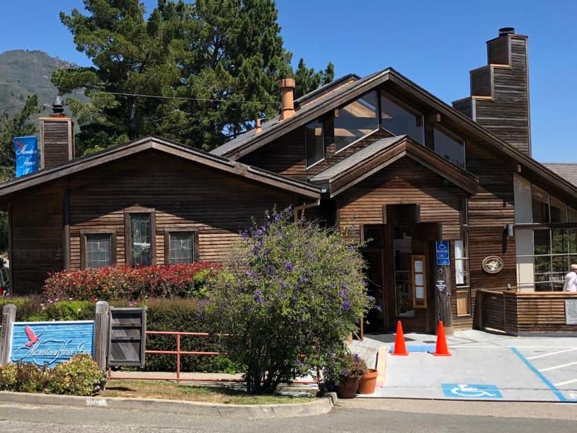 Mountain Home Inn building with wood siding, large windows, and landscaping under a clear sky.