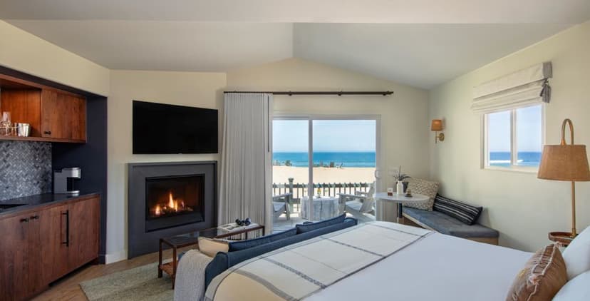 Bedroom with fireplace and balcony overlooking beach and ocean at The Sanctuary Beach Resort
