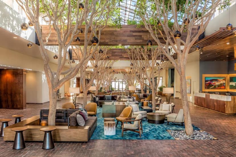 Hotel lobby lounge with indoor trees, modern seating, and a glass ceiling, Portola Hotel & Spa