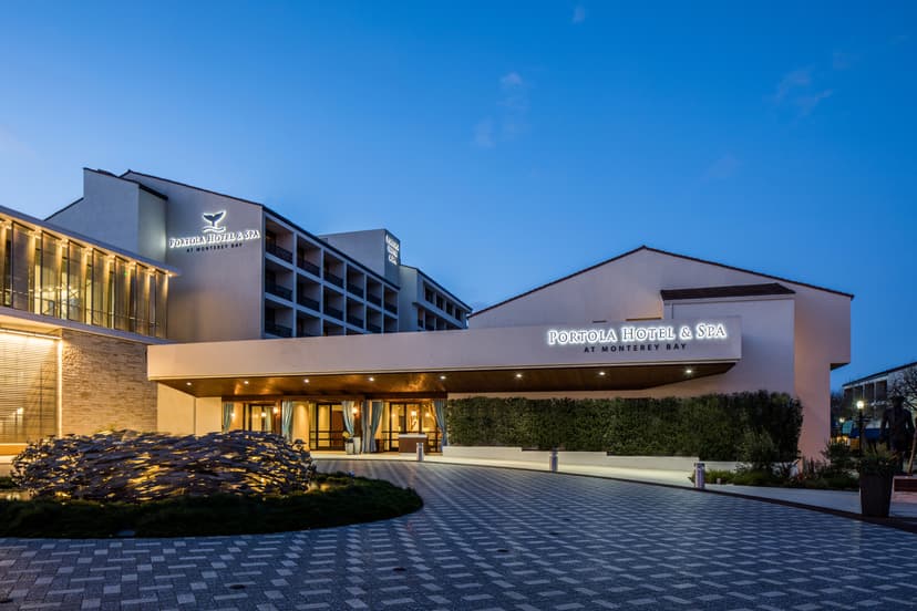 Portola Hotel & Spa at Monterey Bay entrance illuminated at twilight with modern architecture and sculpture.