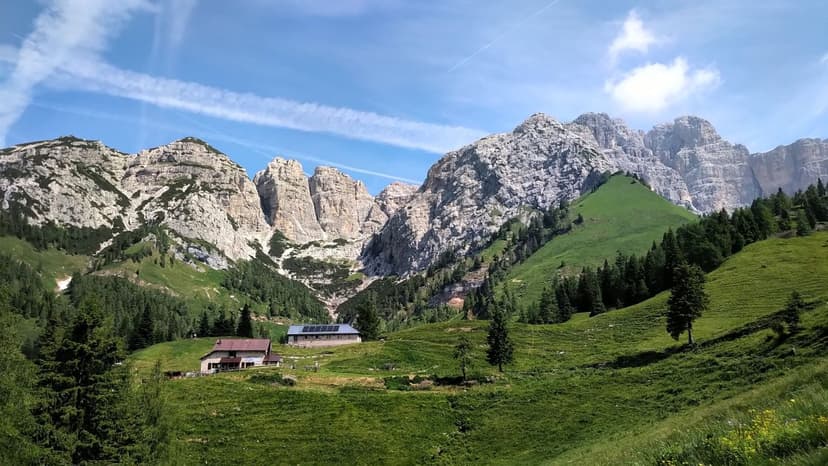 Rifugio Boz Ena mountain hut nestled in green alpine meadow below rocky peaks