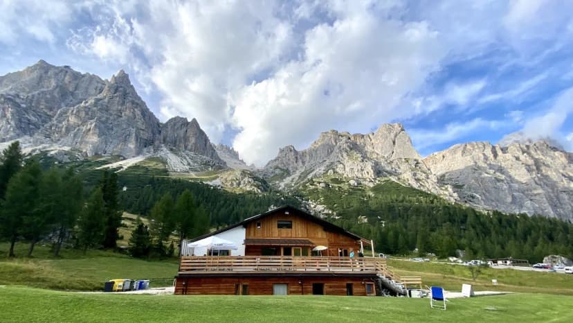 Rifugio Col Gallina mountain hut with wooden deck set against rugged Dolomites peaks.