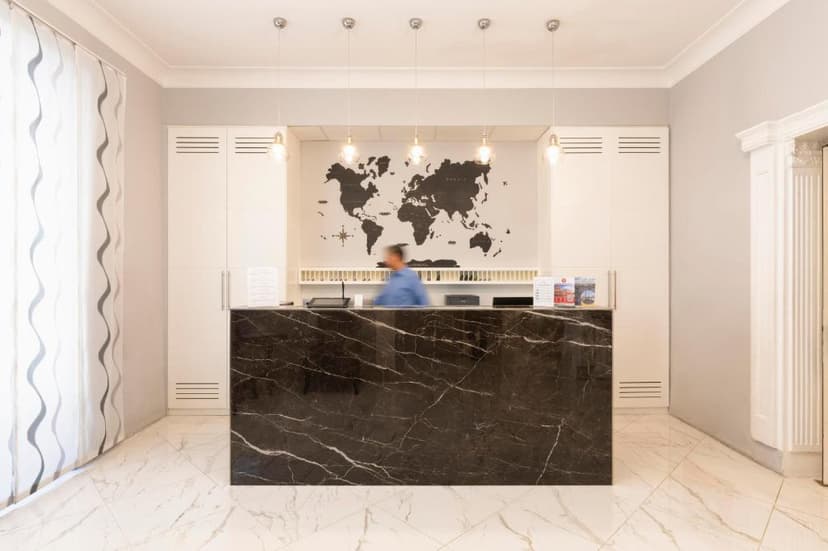 Hotel reception desk with black marble counter and world map backdrop
