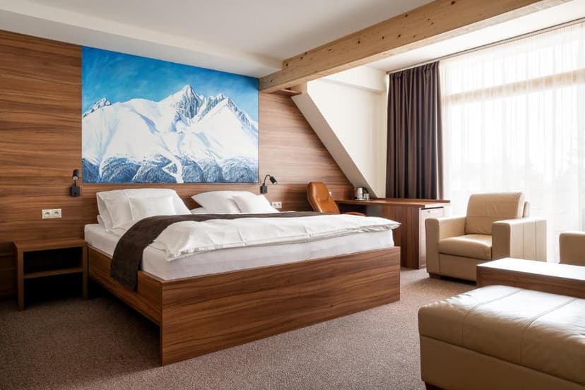 Hotel room with wooden accents, white bedding, and a large painting of snowy mountains.